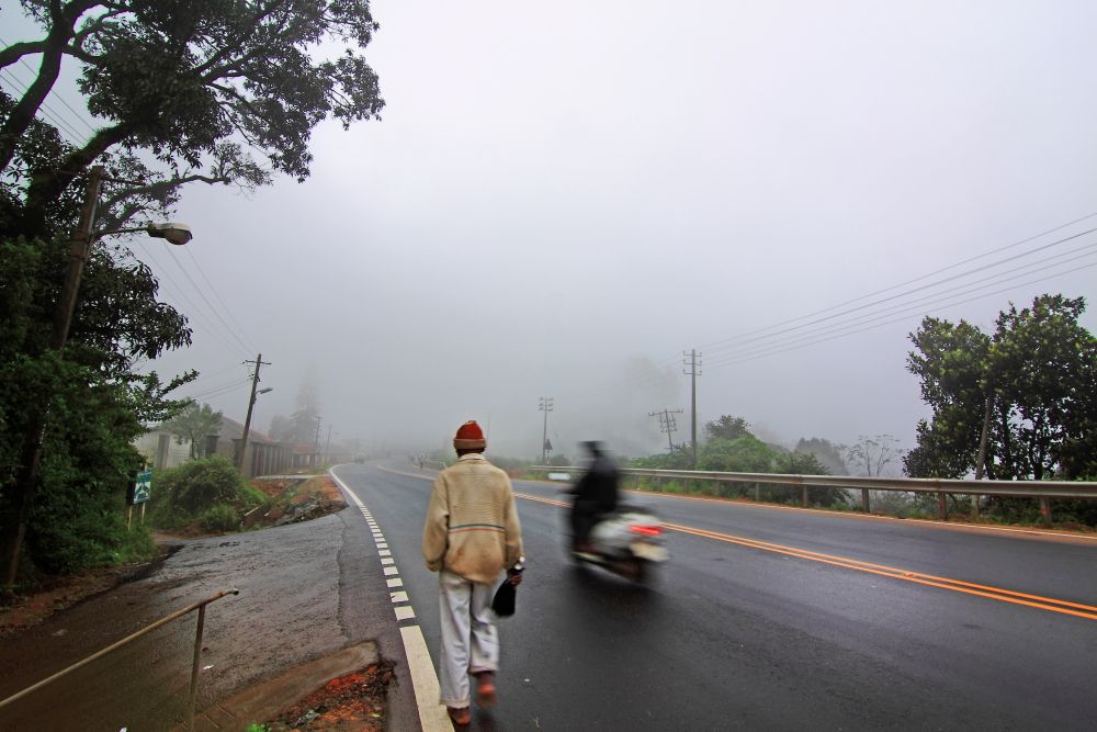 Man walks along the highway in Madikeri Highway in Madikeri